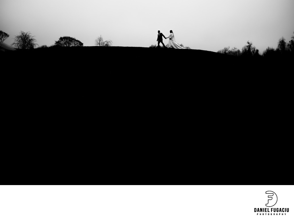 Bride and groom walking on a hill