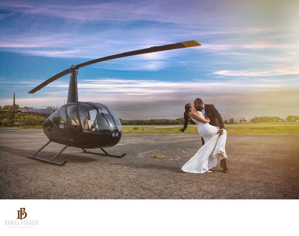 Wedding couple kissing by helicopter