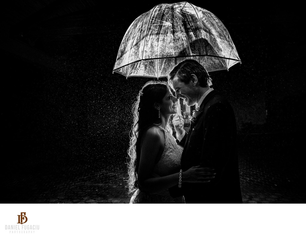 Bride and groom under an umbrella in the rain