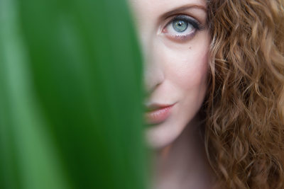 Beauty portrait of woman with corn leaf covering face