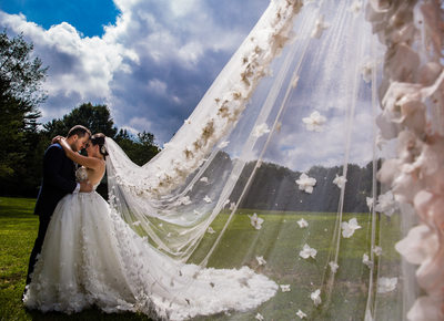 Portrait of bride and groom with veil in the wind