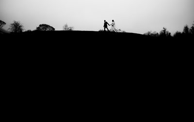 Bride and groom walking on a hill