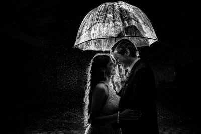 Bride and groom under an umbrella in the rain