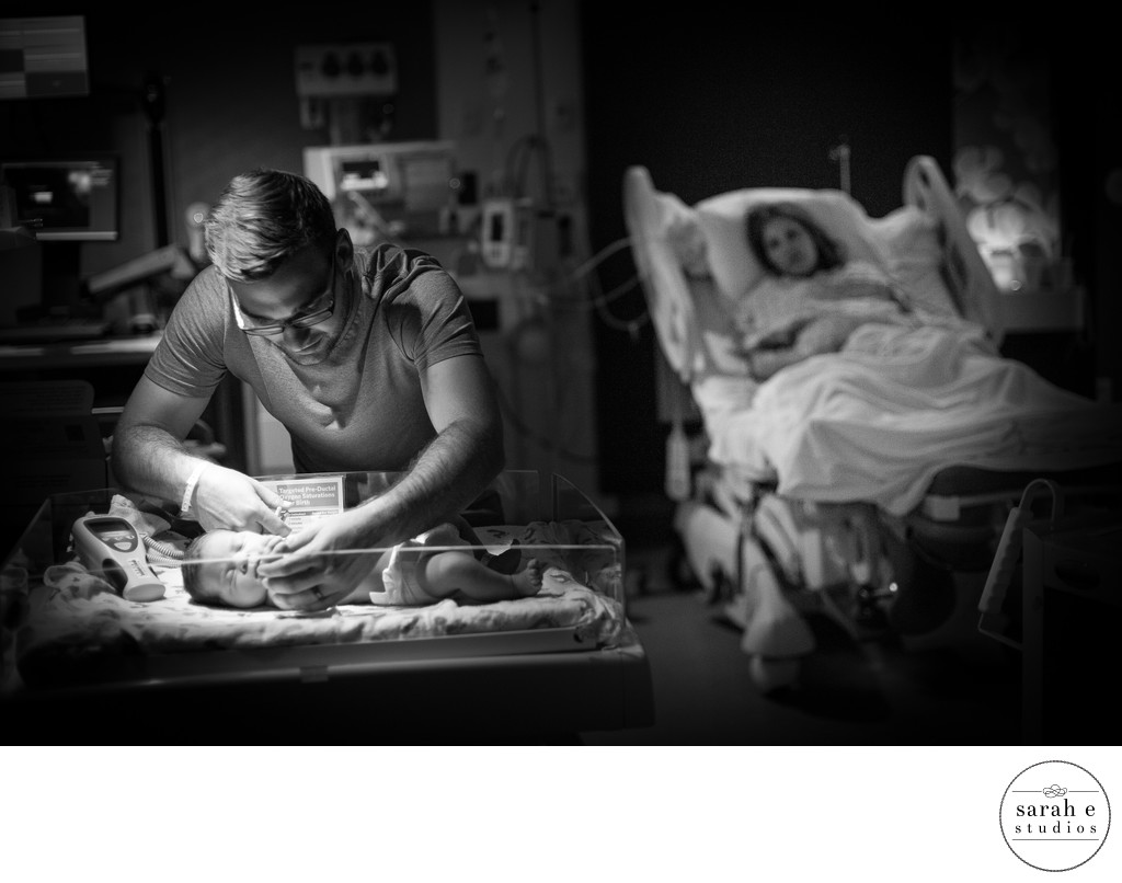 Darling View of Dad and Newborn Baby with Mom Watching