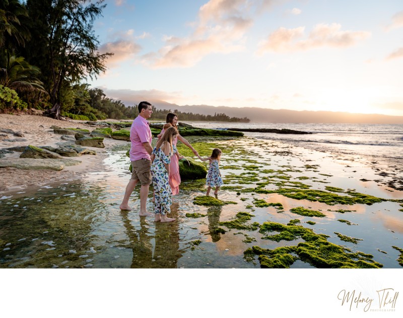 Family enjoying the sunset on a beautiful beach in Hawaii, Oahu