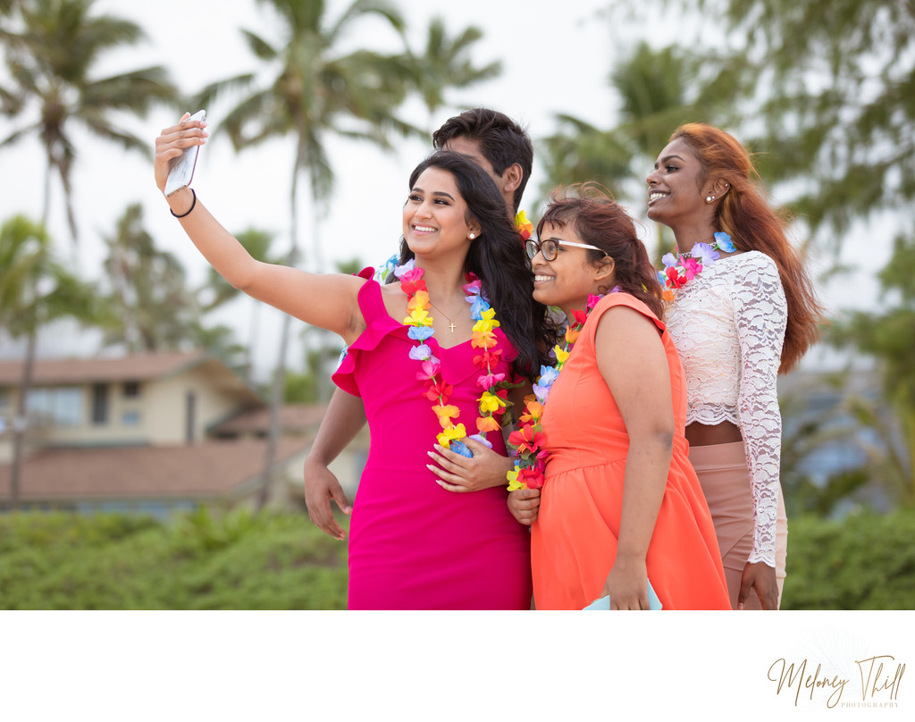 Wedding guests taking selfies on the beach