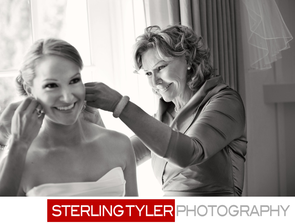 bride and mom put on earrings and jewelry candid photo