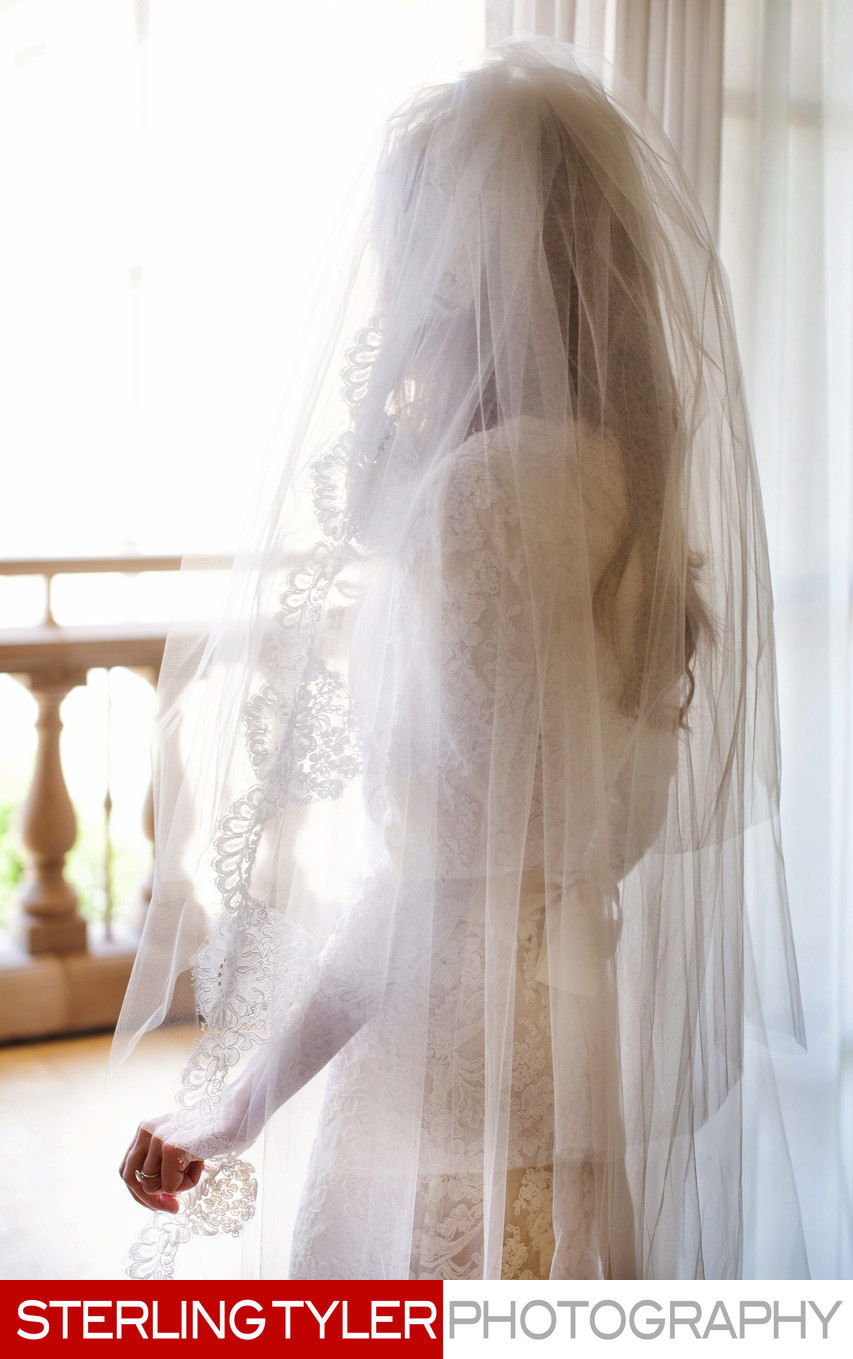 jewish bride with veil overlooking window 