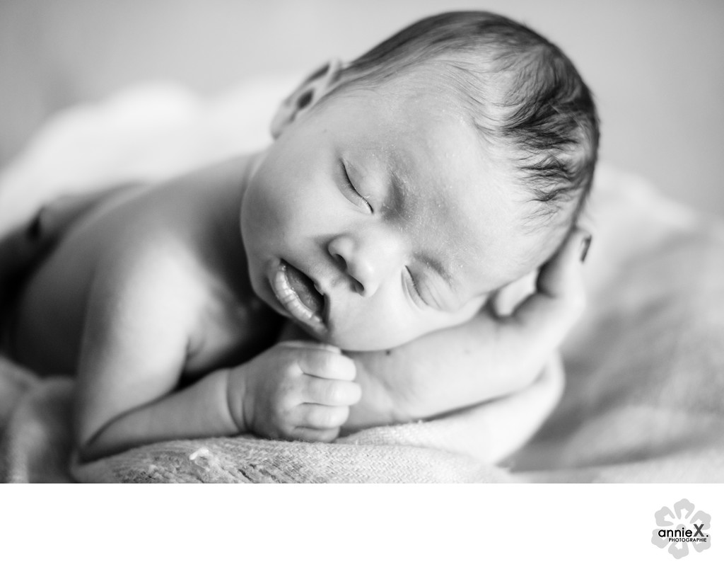 newborn sleeping in black white