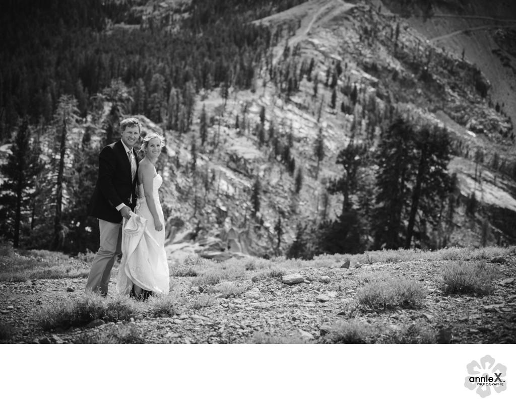 black and white image of bride and groom on mountain top