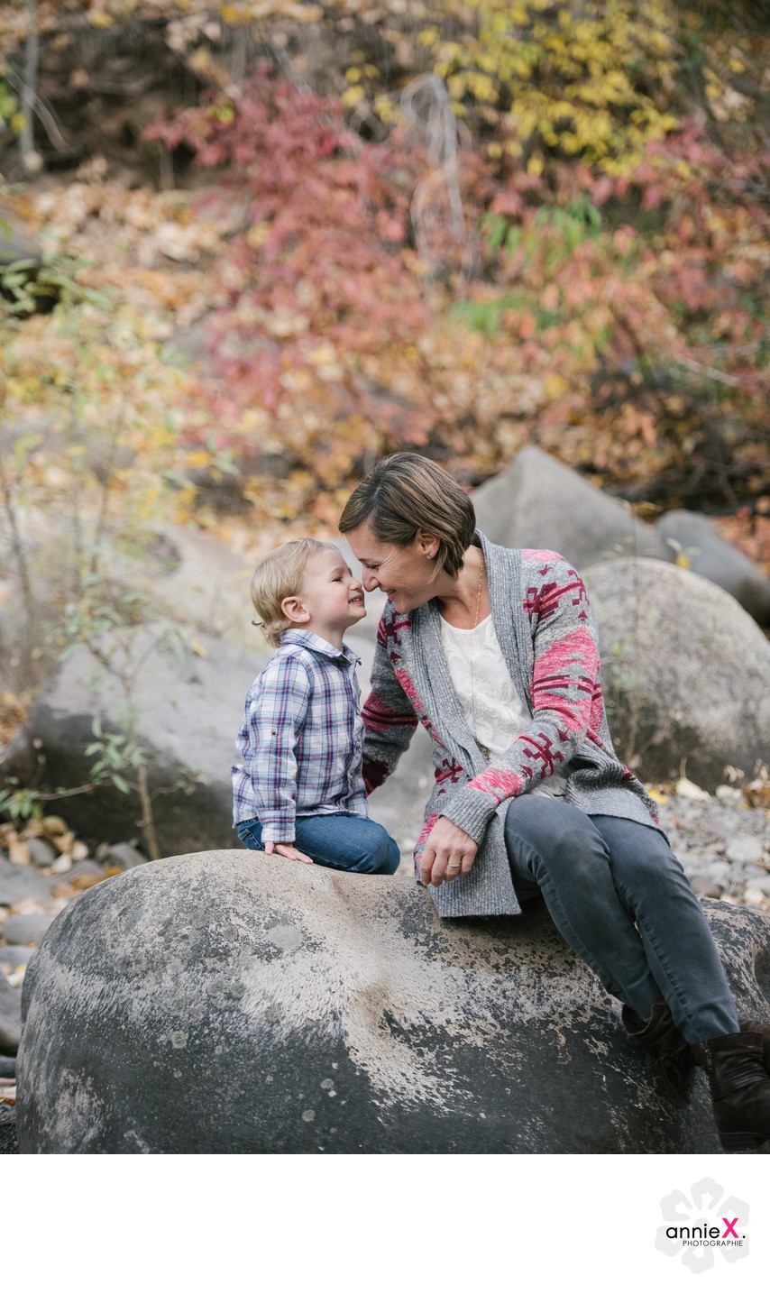 Mother and toddler son on rock in truckee river