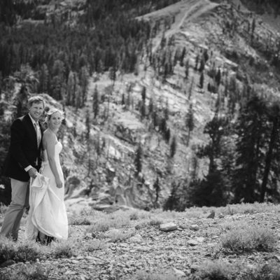 black and white image of bride and groom on mountain top