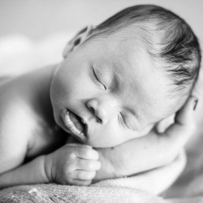 newborn sleeping in black white