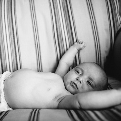 stretching baby on striped chair