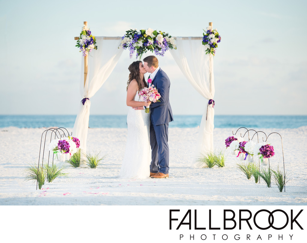 couple kiss floral arch beach wedding siesta key