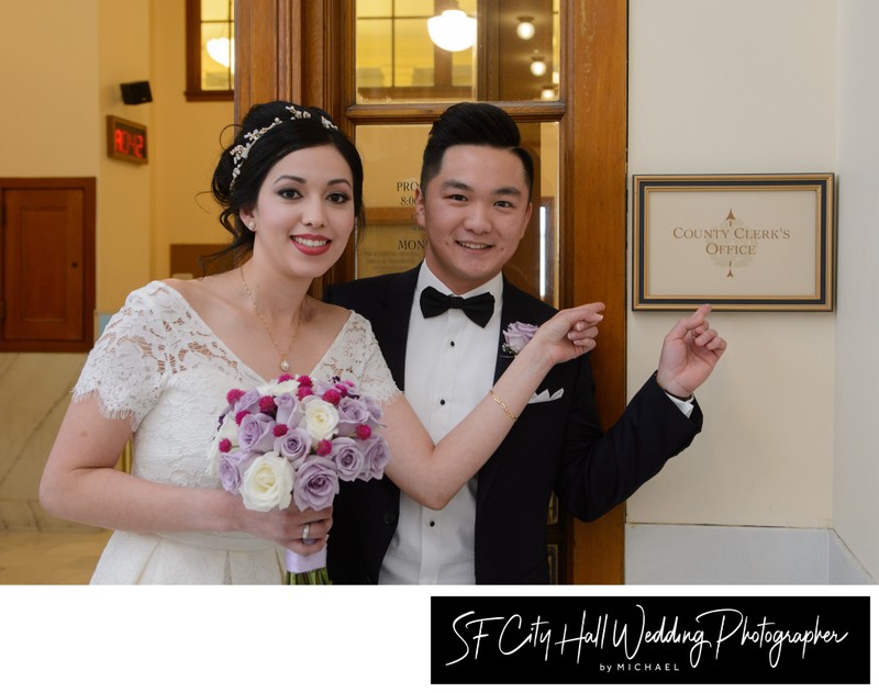 Happy Couple Pointing at County Clerk Sign