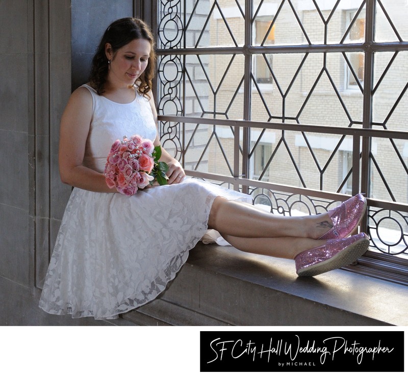 City Hall Bride looks at Bouquet in front of 3rd Floor Window