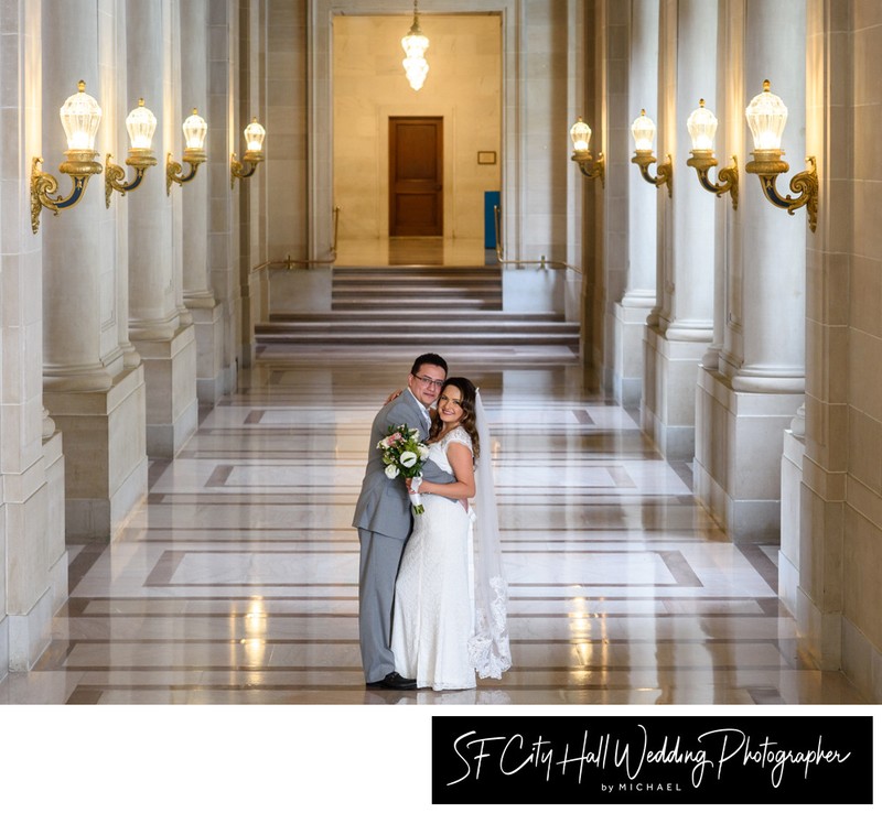 Groom hugs bride for city hall wedding picture