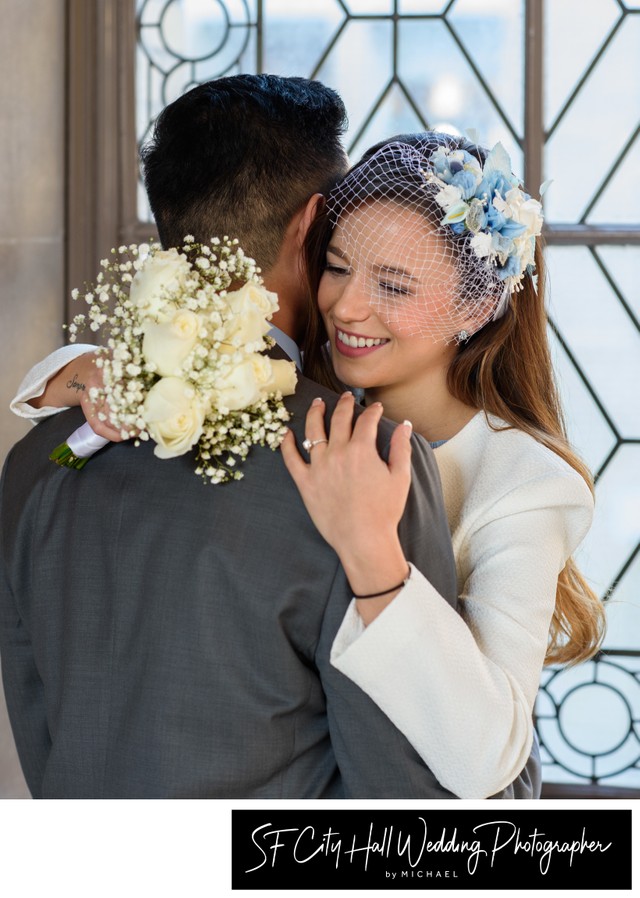 Bride with groom close up at SF City Hall window