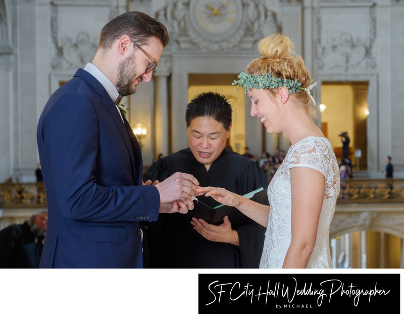 bride smiling as she receives her wedding ring