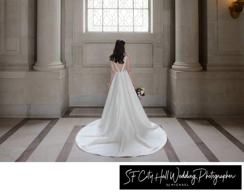 City hall bride with big dress standing in front of large window
