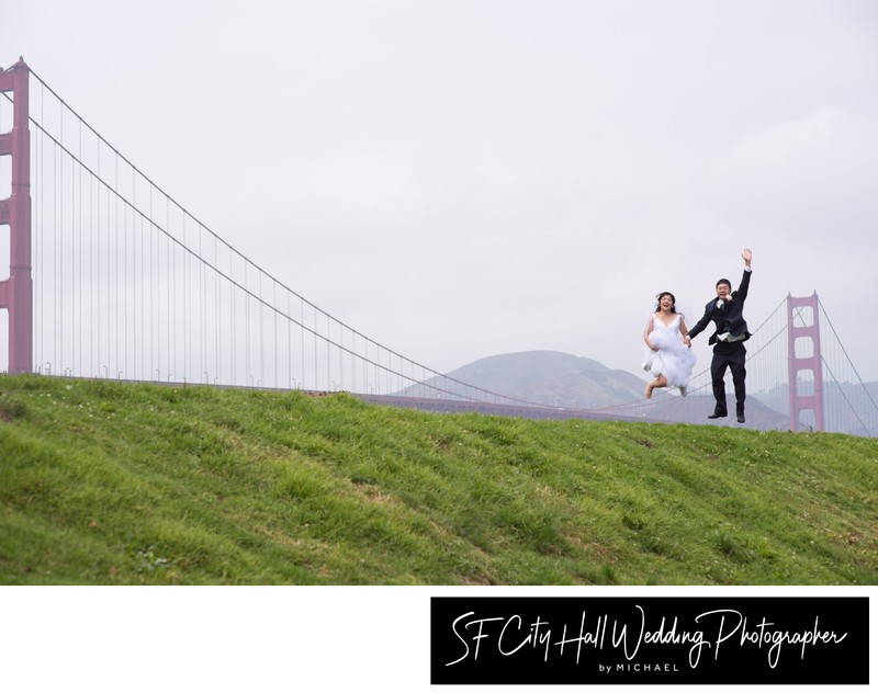 bride and groom Jumping at Crissy Field in front of Golden Gate Bridge