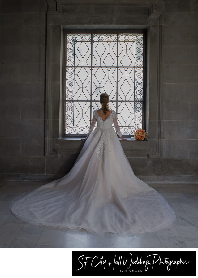 Elegant bridal pose showing the back of the wedding dress for photos