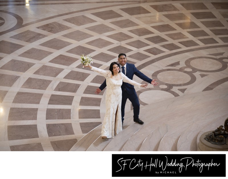 Bride and groom celebrating at the base of The Grand Staircase