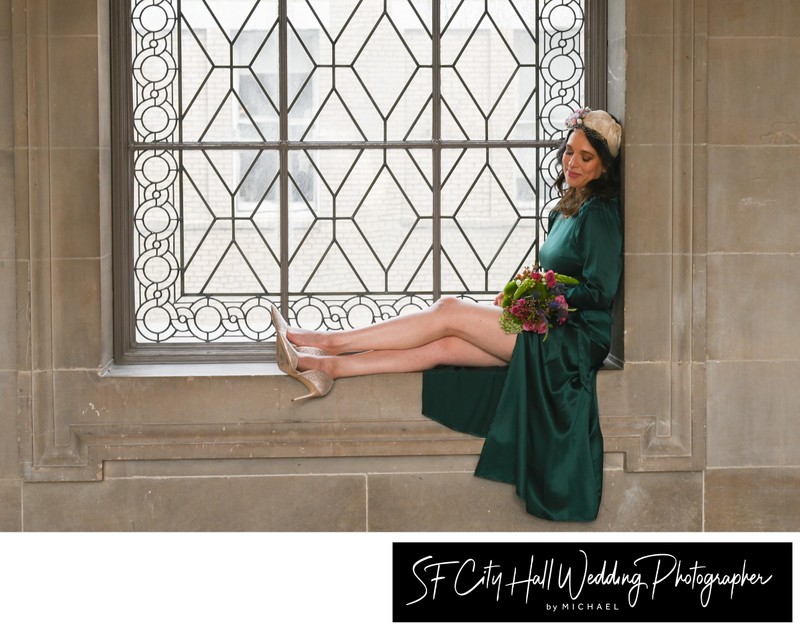 Bride in San Francisco city hall window with flashy green wedding dress