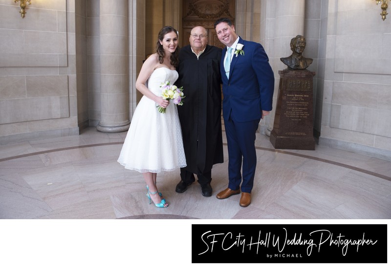 Luca and Christine posing with San Francisco city hall Marriage Commissioner