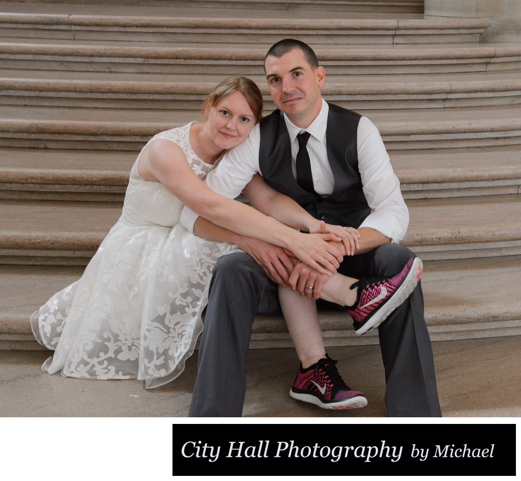 Bride and groom on stairs with her red wedding sneakers