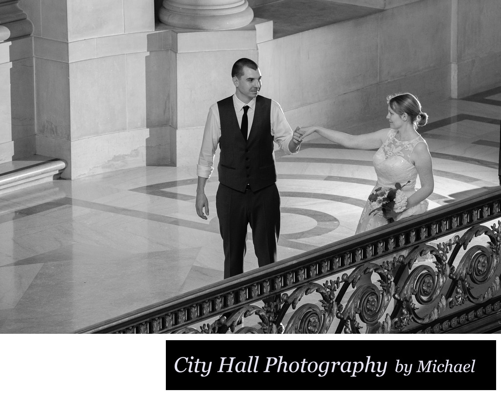 Hand holding bride and groom on the Mayor's Balcony