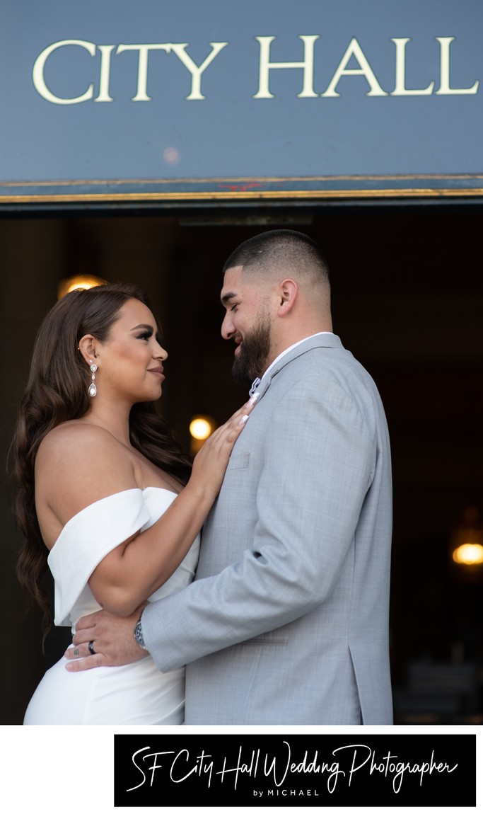 Close up of San Francisco city hall entrance sign with bride and groom