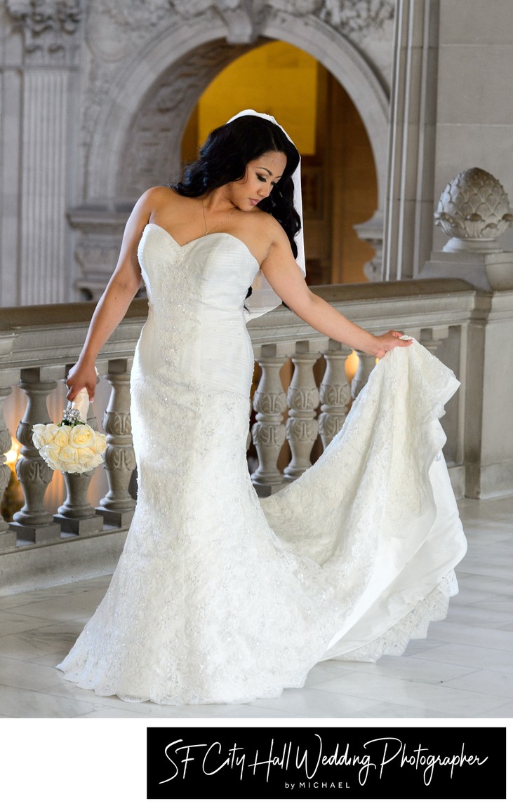 A San Francisco city hall bride holds her train on the 3rd floor of the building