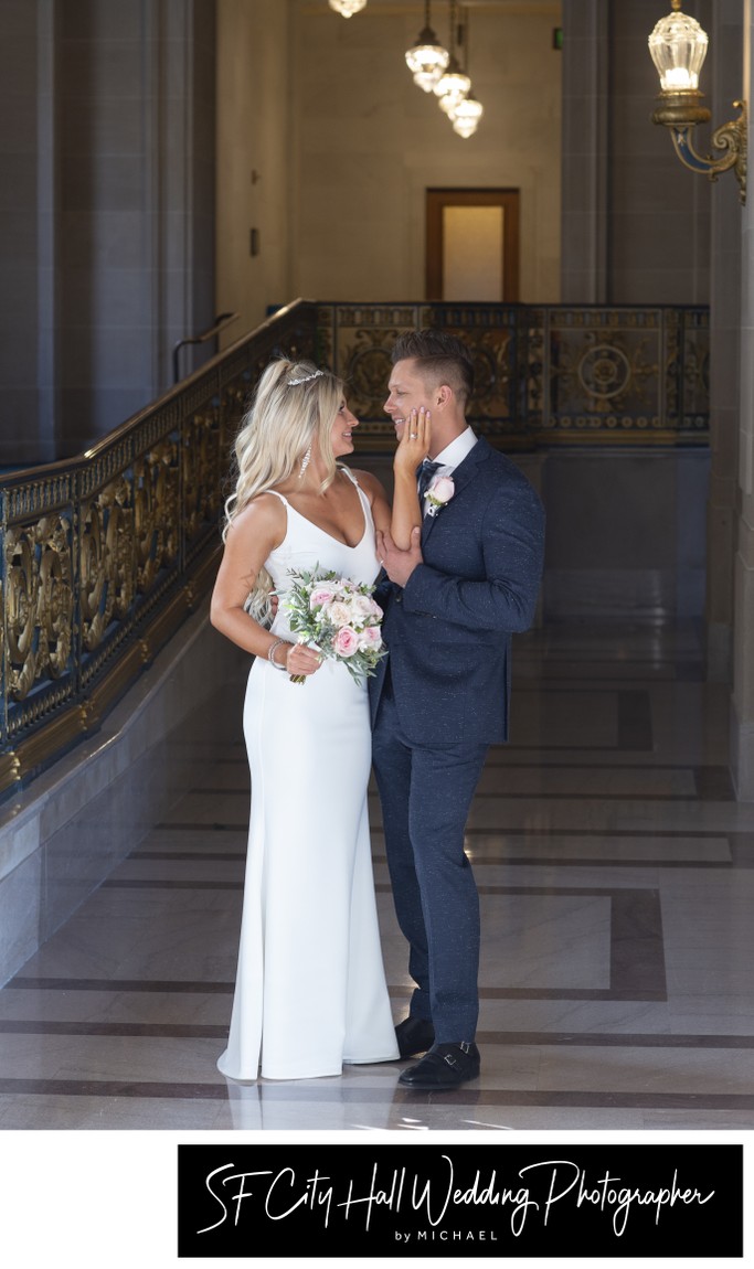 bride touching grooms face - San Francisco city hall wedding photography