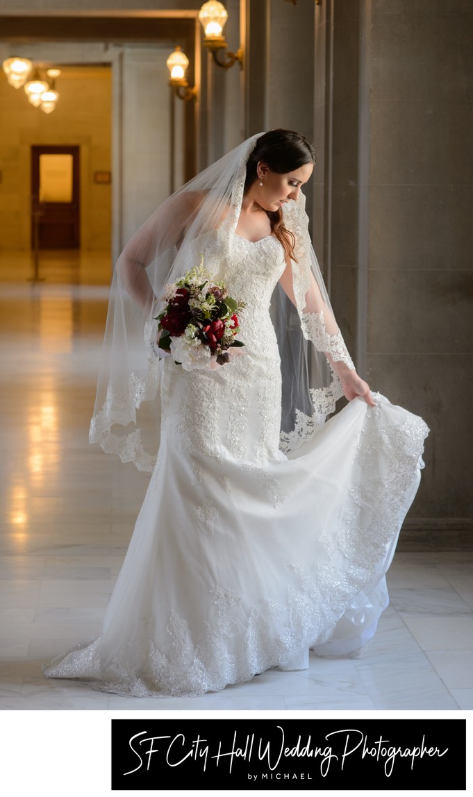 San Francisco city hall wedding picture of bride holding her train