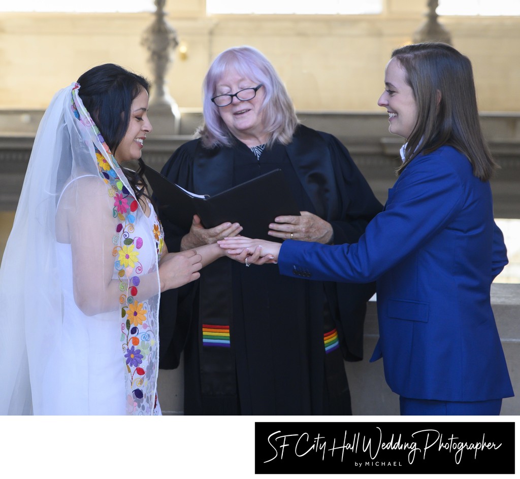 Beautiful LGBTQ Brides exchanging rings at SF city hall