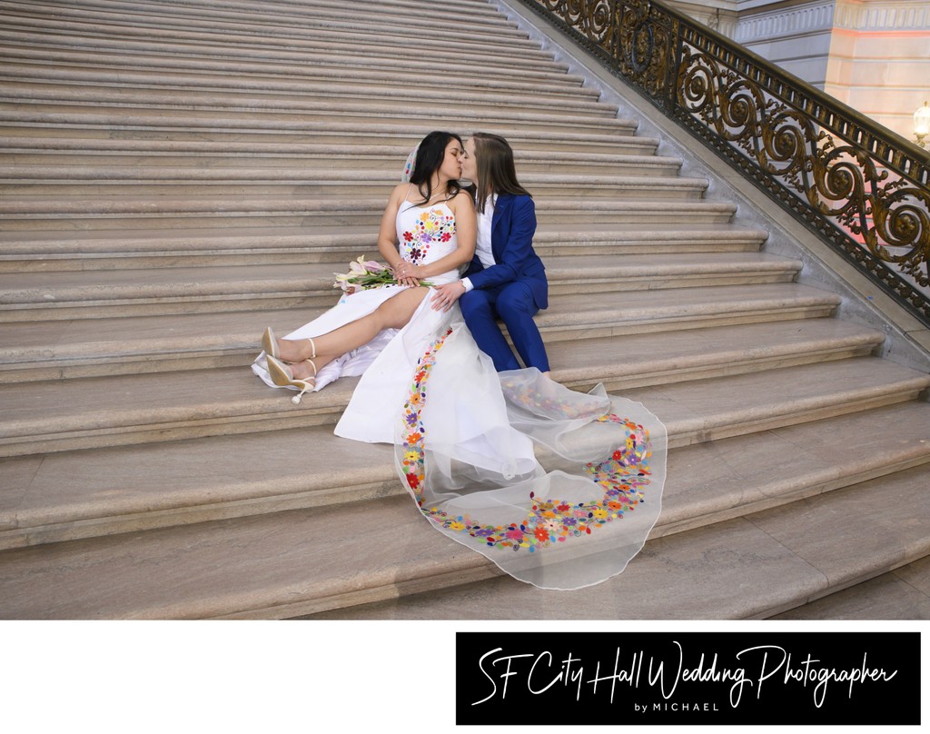 LGBTQ+ brides kissing on the Grand Staircase at San Francisco city hall