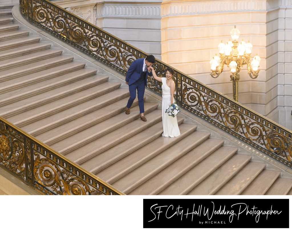 City Hall Groom kissing his bride's hand in San Francisco