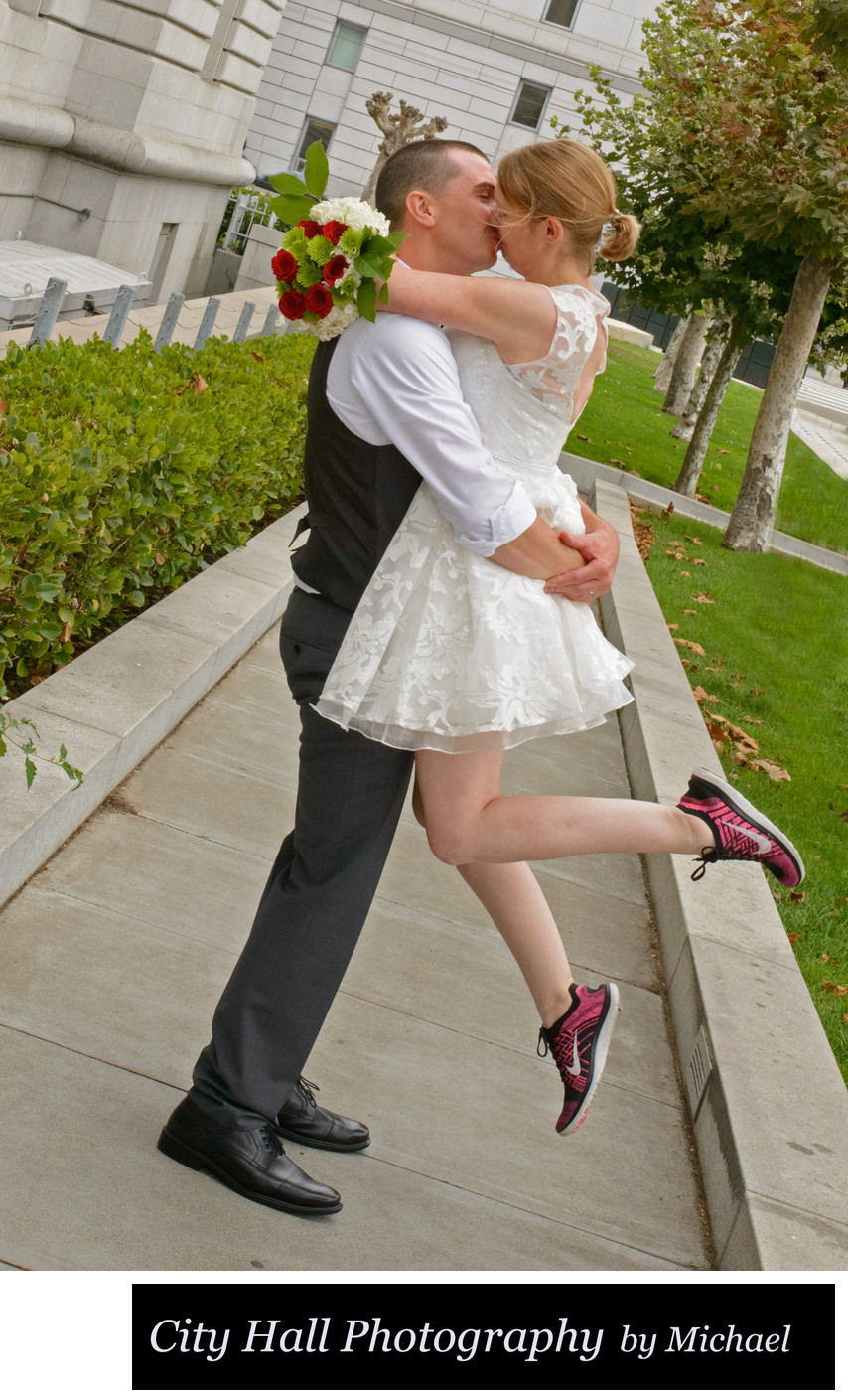 Lift kiss outside of San Francisco City Hall with red sneakers