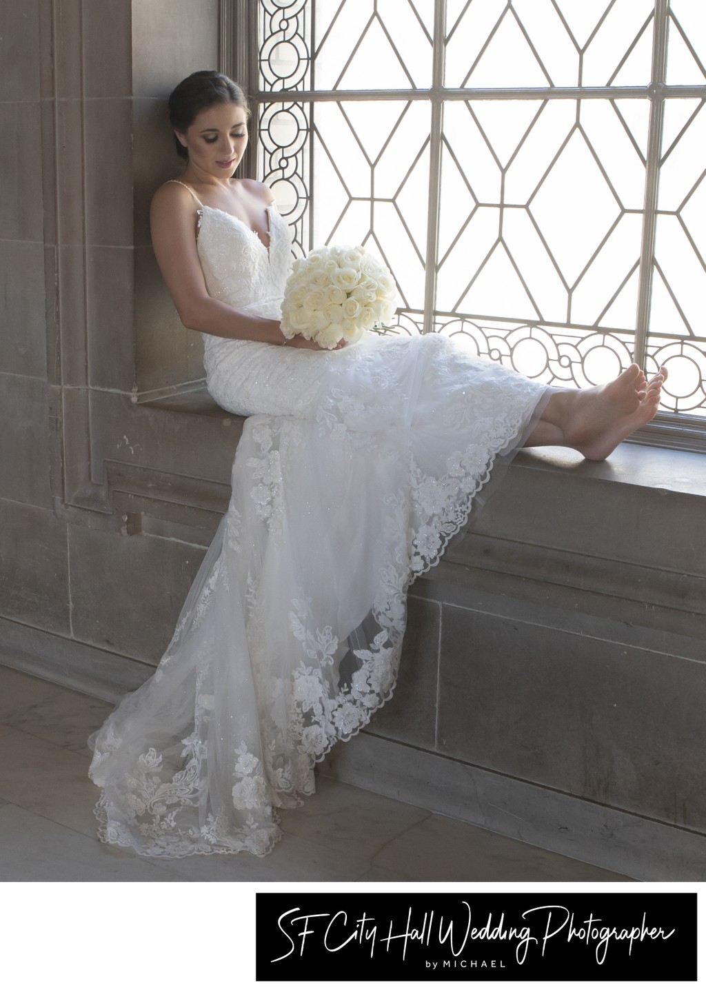 San Francisco city hall bride contemplates her bouquet - wedding photography