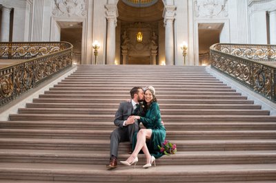 newlyweds sitting on grand staircase for wedding photographer