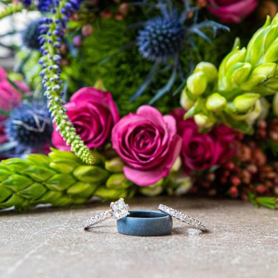 Still life photo of wedding rings and bouquet