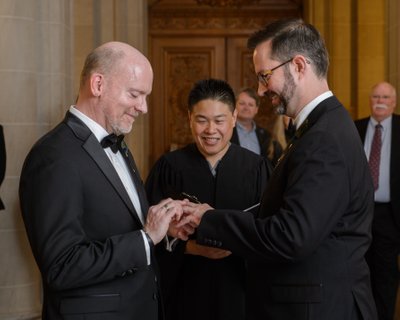 Gay grooms exchanging rings at San Francisco city hall