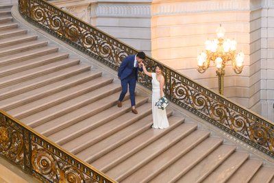 City Hall Groom kissing his bride's hand in San Francisco