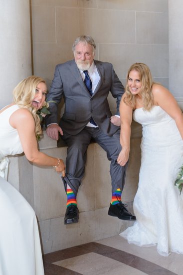 LGBTQ Couple with Dad showing his rainbow socks at SF City Hall
