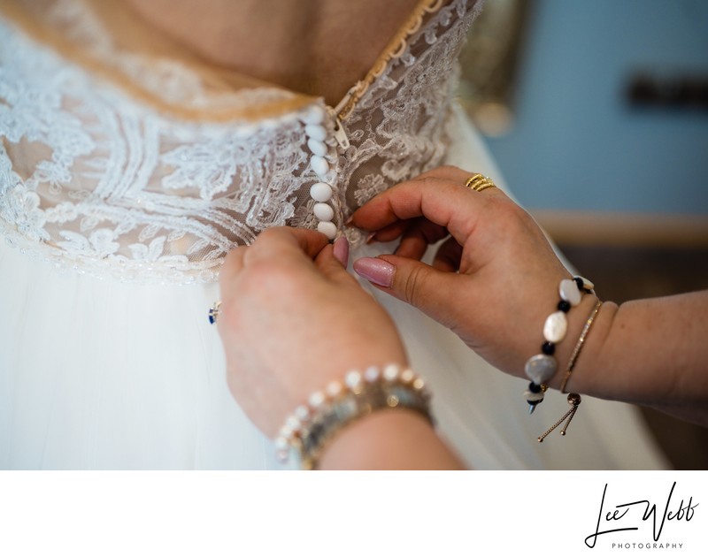 Bride's dress being fastened