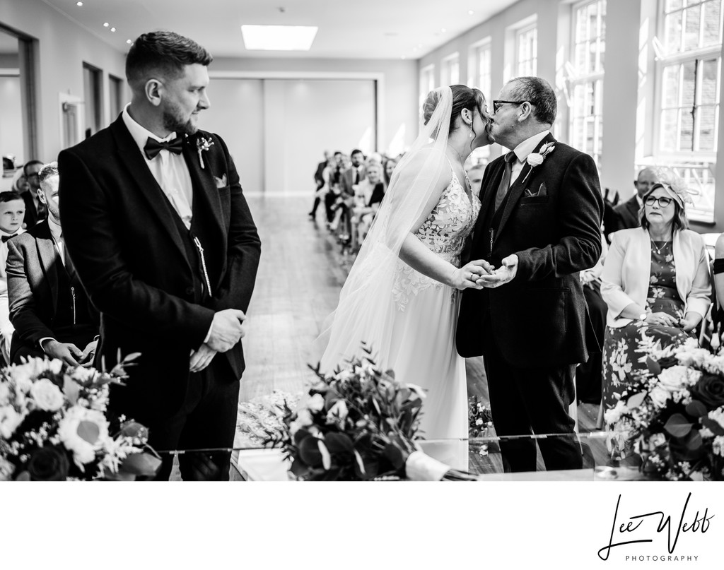 Bride and father of the bride kiss Bredenbury Court