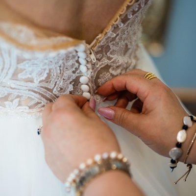 Bride's dress being fastened