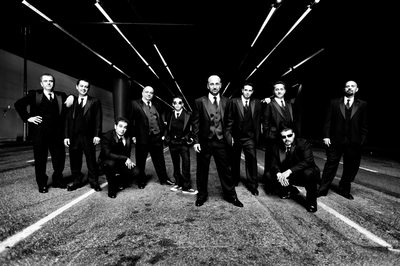 Creative black and white image of large wedding party and groomsmen in a gritty urban location.